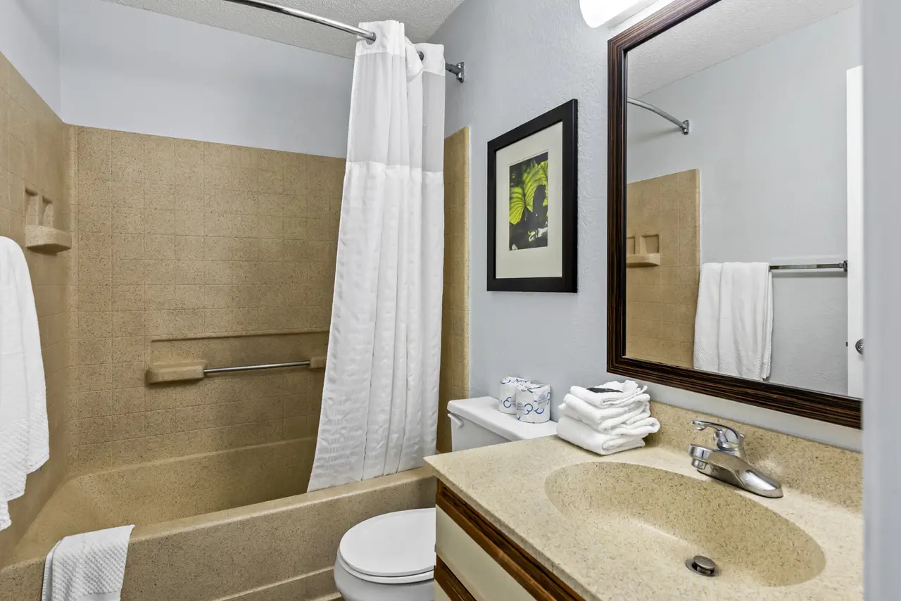 Guest bathroom with vanity, bathtub and shower curtain