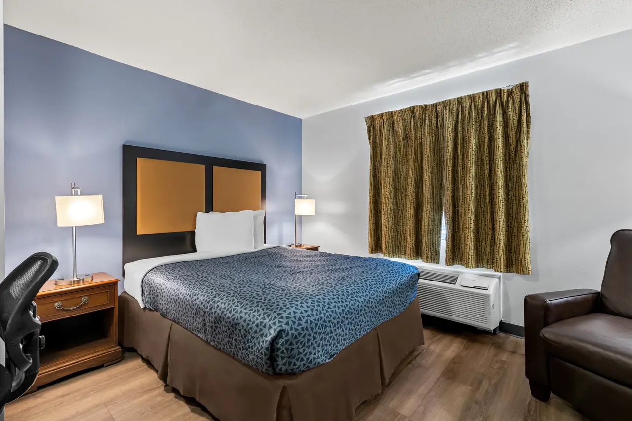 Guest room with queen bed, work chair and window